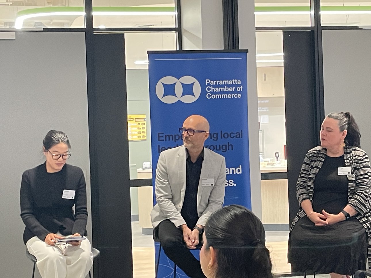 Three panellists seated in front of a Parramatta Chamber of Commerce banner during a Small Business Month Q&A.